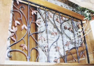 Decorative wrought iron railing with leaf motifs, showcasing intricate craftsmanship and design.